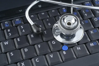 Laptop computer and stethoscope representing digital health data management in hospitals.