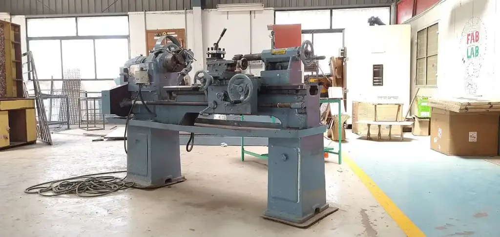 Clear view of an industrial precision metal lathe machine turning raw steel components inside an Indian manufacturing factory workshop.
