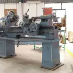 Clear view of an industrial precision metal lathe machine turning raw steel components inside an Indian manufacturing factory workshop.