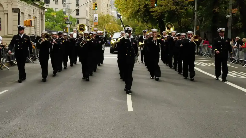 Formal parade procession with ceremonial marchers advancing along Fifth Avenue during the New York City Columbus Day Parade.