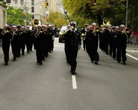 Formal parade procession with ceremonial marchers advancing along Fifth Avenue during the New York City Columbus Day Parade.
