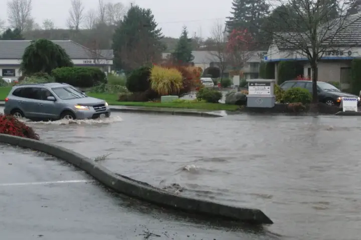 Flood water covering a street with vehicles in an urban area