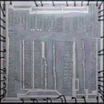 Detailed close-up view of an exposed silicon microchip die showing microscopic circuit pathways.