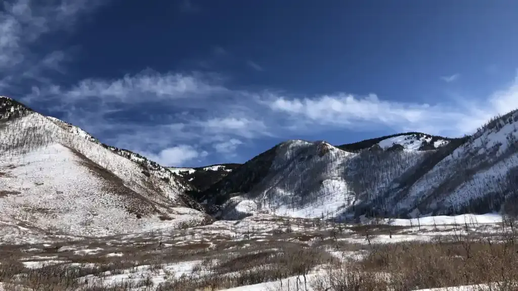 Heavy snow covering alpine mountain slopes and evergreen forests in Utah's La Sal Mountain range