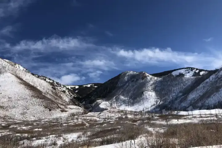 Heavy snow covering alpine mountain slopes and evergreen forests in Utah's La Sal Mountain range