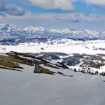 Deep snow blanket covering an alpine mountain plateau and roadway pass in Montana