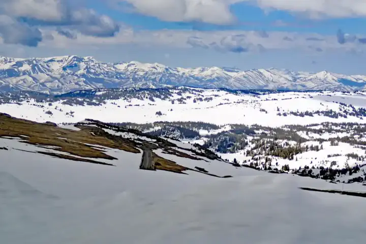 Deep snow blanket covering an alpine mountain plateau and roadway pass in Montana