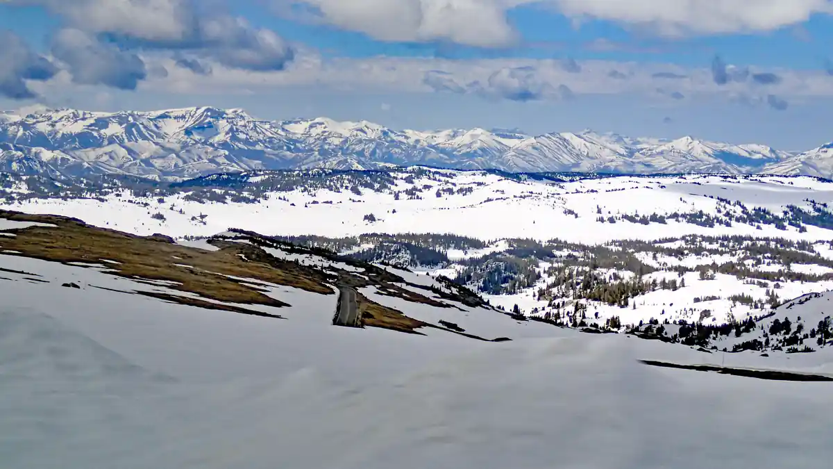 Deep snow blanket covering an alpine mountain plateau and roadway pass in Montana