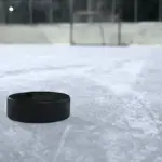 Black ice hockey puck resting on a clear outdoor ice rink, representing the hockey context of the Montreal Metros explainer.