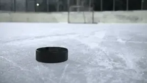 Black ice hockey puck resting on a clear outdoor ice rink, representing the hockey context of the Montreal Metros explainer.