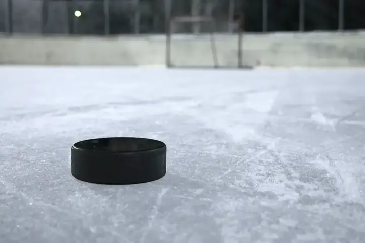 Black ice hockey puck resting on a clear outdoor ice rink, representing the hockey context of the Montreal Metros explainer.