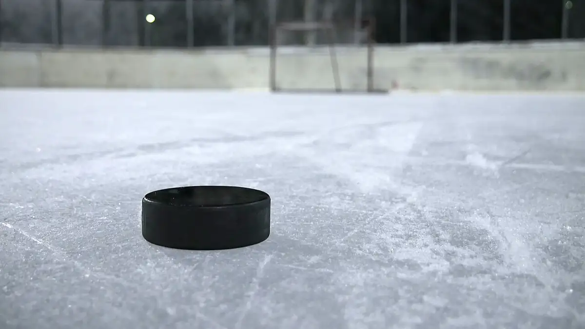 Black ice hockey puck resting on a clear outdoor ice rink, representing the hockey context of the Montreal Metros explainer.