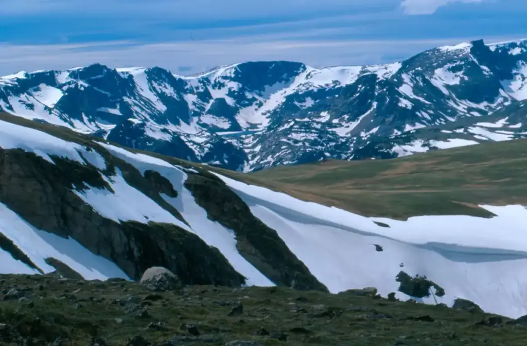 A highway corridor through snow-covered mountain terrain in the Rocky Mountains.