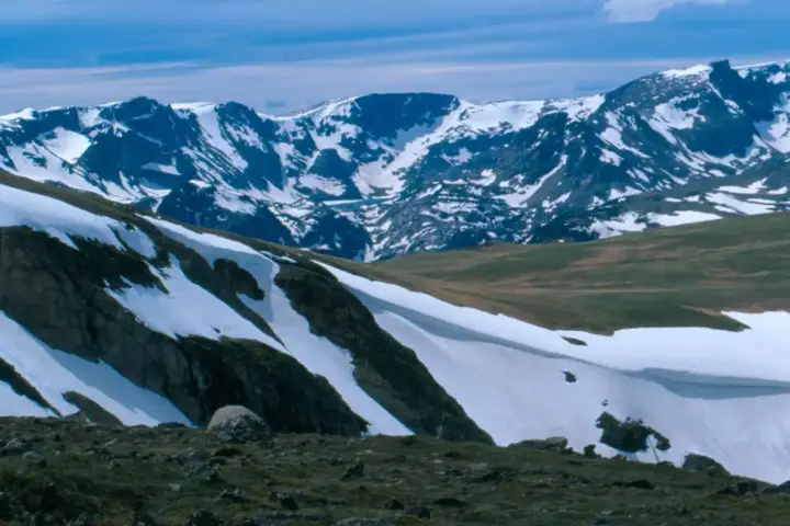 A highway corridor through snow-covered mountain terrain in the Rocky Mountains.