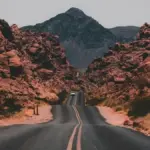 A multilane highway running through a forested mountain landscape.