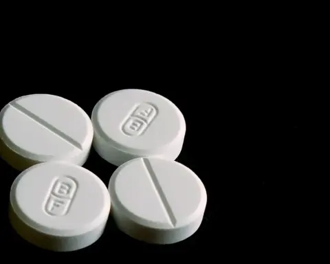 White 500-milligram acetaminophen tablets displayed on a clean reflective surface.