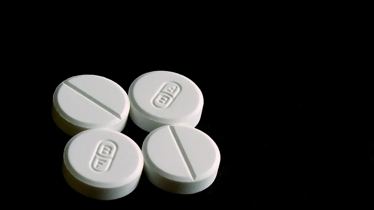 White 500-milligram acetaminophen tablets displayed on a clean reflective surface.
