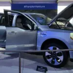 Front three-quarter view of a dark Ford F-150 Lightning all-electric pickup truck parked outdoors.