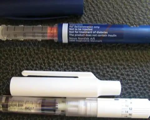A medical subcutaneous injection pen resting horizontally on a clean surface.