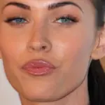 Close-up photographic portrait of actress Megan Fox facing forward at a red-carpet media appearance.