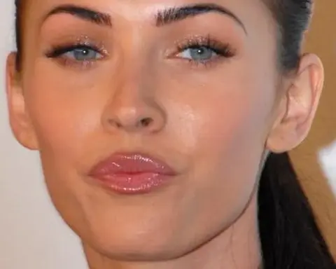 Close-up photographic portrait of actress Megan Fox facing forward at a red-carpet media appearance.