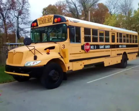 Yellow school bus at Saint Xavier High School, illustrating student transportation safety for intercity travel events.