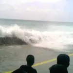 A large powerful ocean wave breaking in the open Pacific sea under an overcast sky
