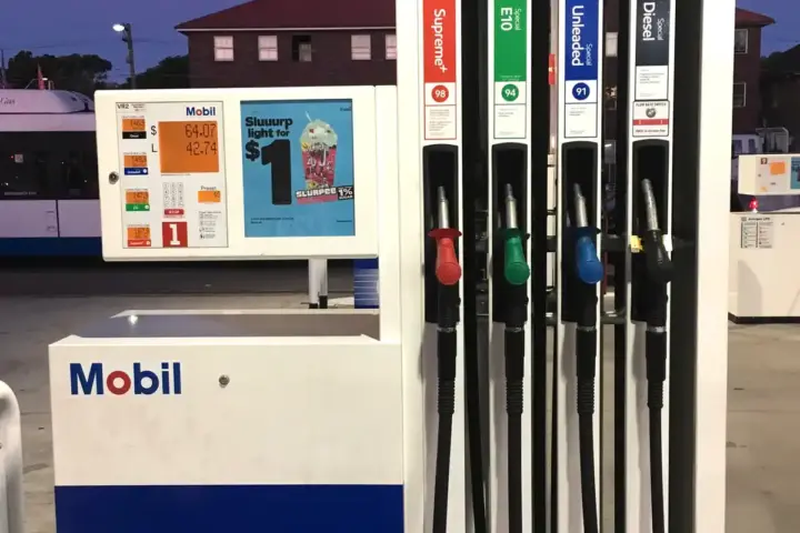 Green fuel nozzles and hoses at a petrol station