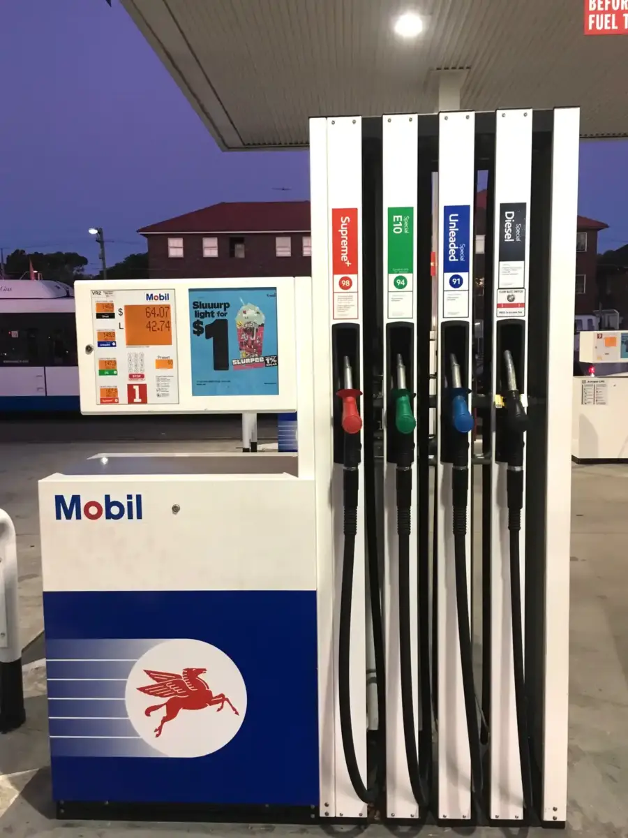 Green fuel nozzles and hoses at a petrol station