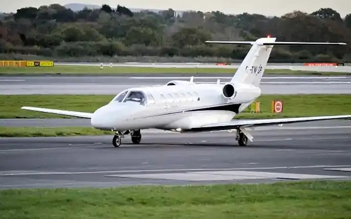 A private jet on an airport runway.