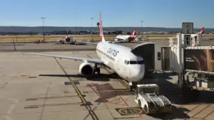 Red and white Qantas passenger aircraft on an Australian airport apron during daytime ground operations
