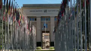 International flags line a government office plaza under clear skies.