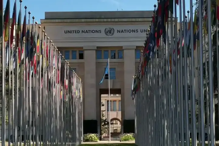International flags line a government office plaza under clear skies.