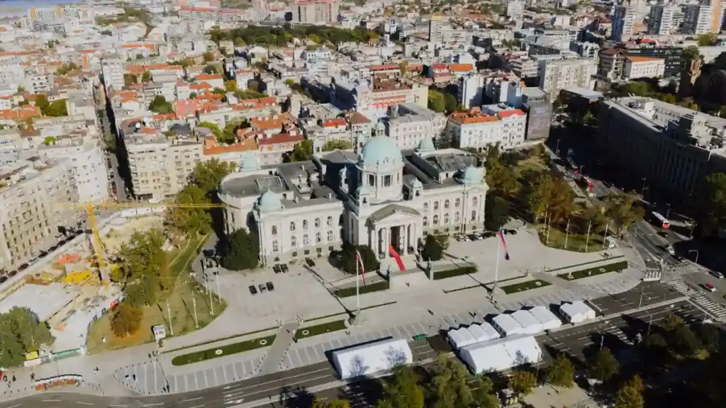 Aerial view of the National Assembly building in Belgrade surrounded by city streets.