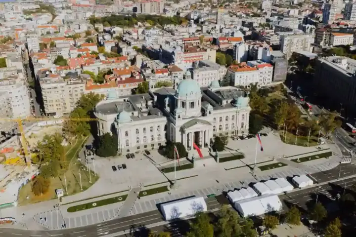 Aerial view of the National Assembly building in Belgrade surrounded by city streets.