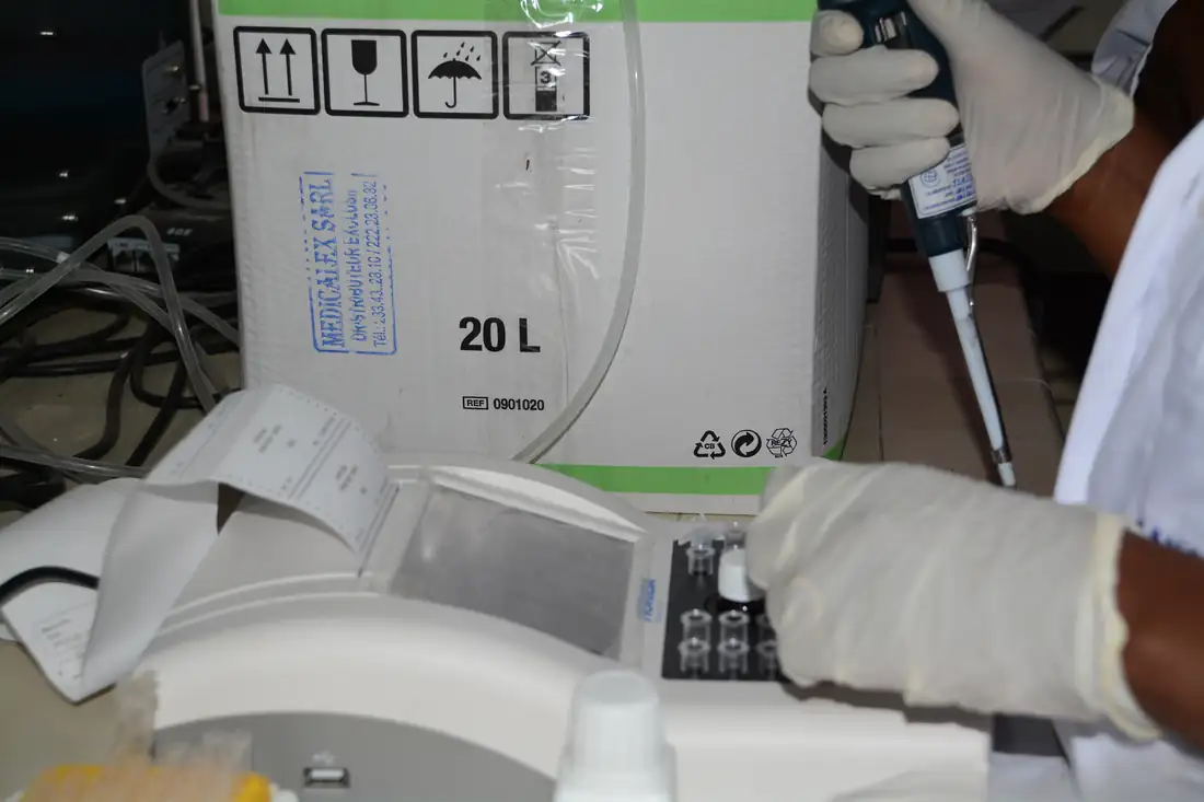 Clinical laboratory technicians in lab coats processing samples, representing research infrastructure for drug trials.