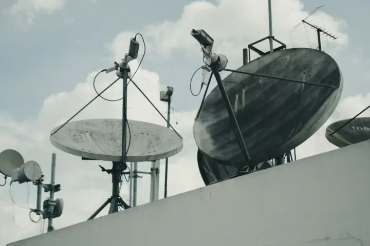 Satellite communication dishes and antennas on a building rooftop