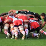 Rugby union forwards contesting a set-piece on a grass pitch.