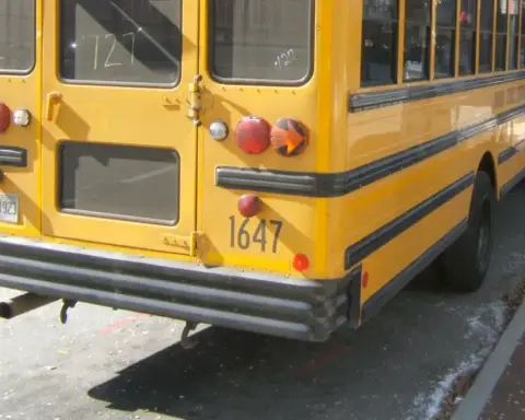 A yellow school bus parked beside a school entrance in Conyers, Georgia, representing school transportation safety after the Salem High School rollover crash.