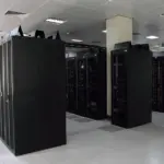 Rows of dark server racks in a bright data-centre aisle