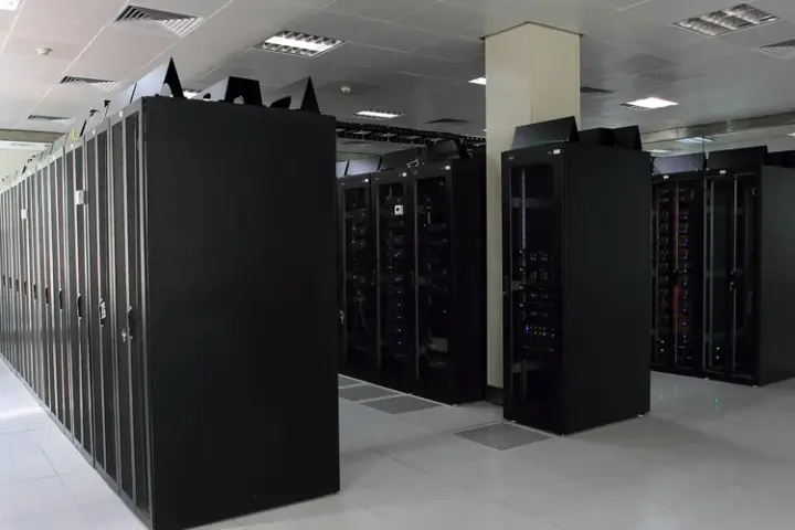 Rows of dark server racks in a bright data-centre aisle