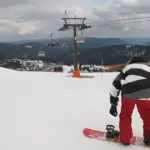 A snowboarder performing a jump during a winter sports event.
