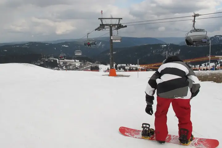 A snowboarder performing a jump during a winter sports event.