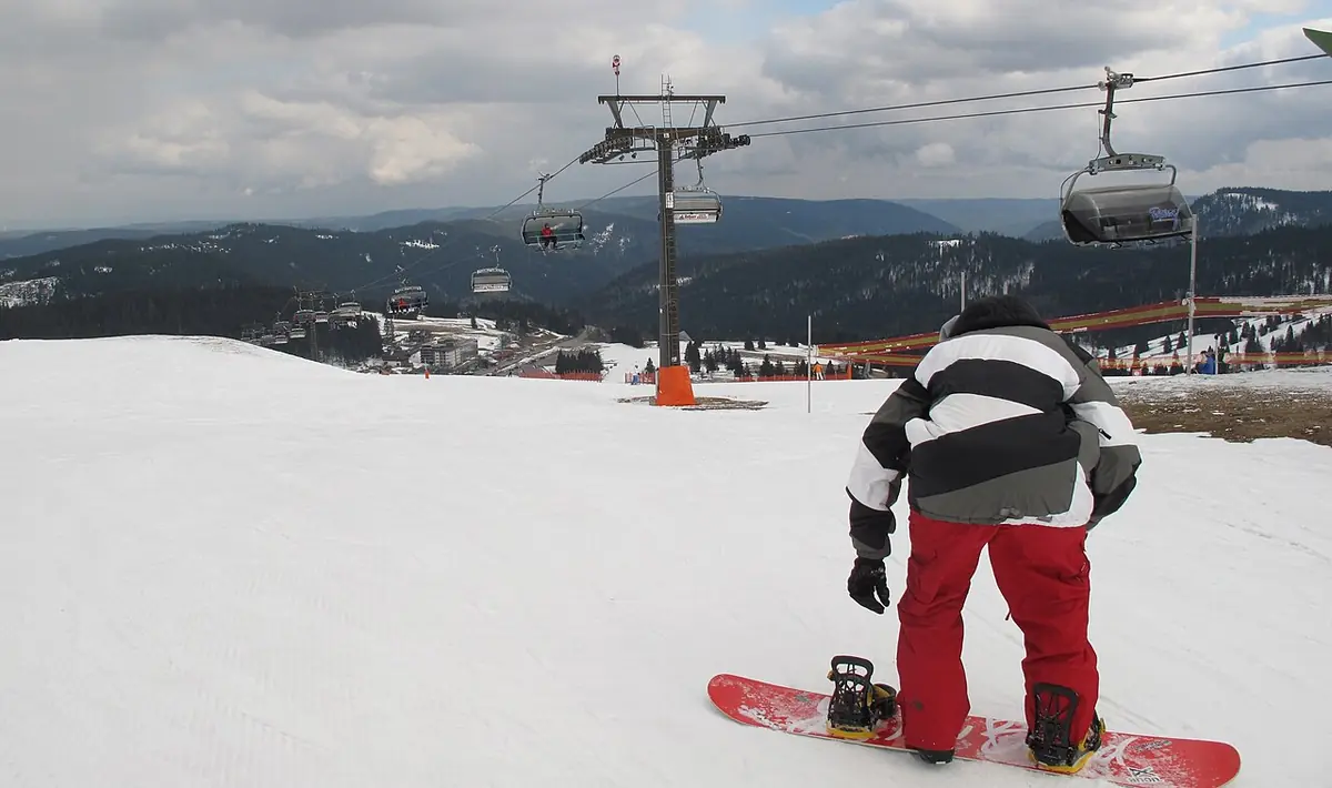 A snowboarder performing a jump during a winter sports event.