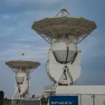 Large satellite dishes and launch infrastructure at SpaceX Starbase in Boca Chica adjacent to coastal Texas wildlife refuge wetlands.