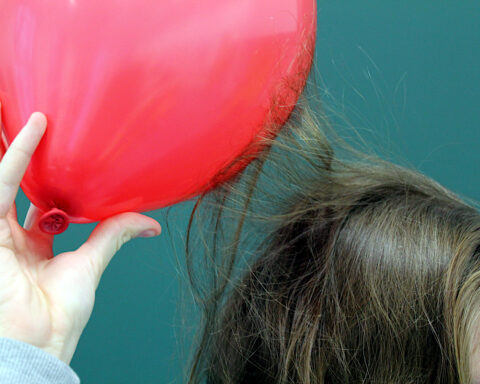 Hair attracted to balloon demonstrating static electricity