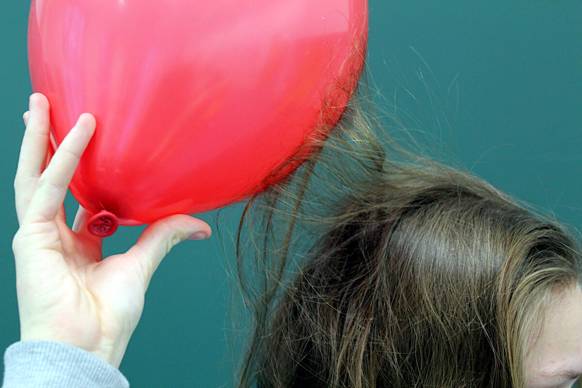 Hair attracted to balloon demonstrating static electricity