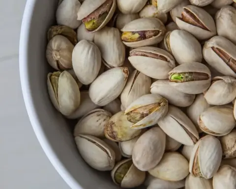 Close-up photograph of whole shelled pistachio nuts in bulk storage prior to commercial packaging and distribution.