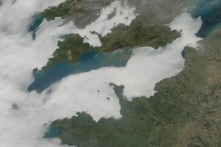 Low cloud cover stretches across the English Channel in a satellite-style atmospheric view.