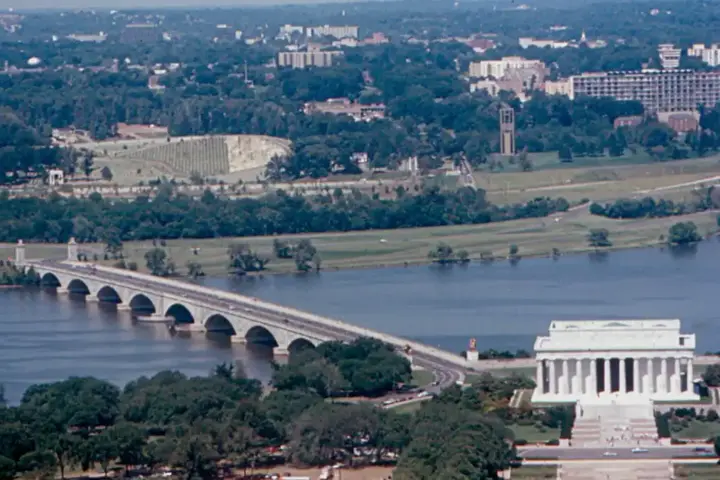 Historical documentary photograph showing the eastern span of the Arlington Memorial Bridge over the Potomac River connecting Washington D.C. to Virginia.